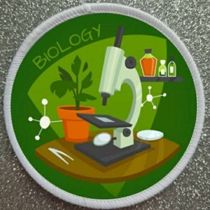 May include: A white and green circular patch with the word "BIOLOGY" in white text. The patch features a cartoon illustration of a microscope, a plant in a pot, and beakers with liquids.