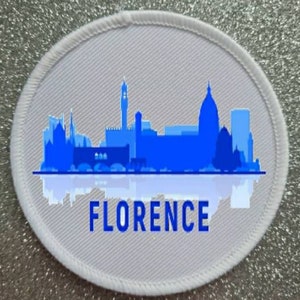 May include: White round patch with a blue silhouette of the Florence skyline and the word "FLORENCE" in blue text.