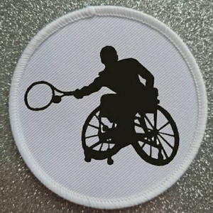 May include: A black and white silhouette of a person in a wheelchair playing tennis. The person is holding a tennis racket and the ball is in the air.
