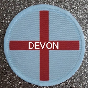 May include: A white circular patch with a red cross and the word "DEVON" in the center.