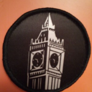 May include: A black and white embroidered patch of Big Ben, the famous clock tower in London, England.