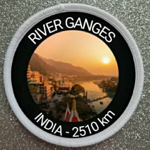 Puede incluir: Un parche redondo blanco con borde negro y una foto del río Ganges en la India. El texto "River Ganges" está escrito en un arco blanco en la parte superior del parche. El texto "India - 2510 km" está escrito en un arco blanco en la parte inferior del parche.