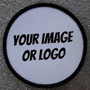 Może przedstawiać: Okrągła biała łatka z czarną obwódką. Tekst "YOUR IMAGE OR LOGO" jest nadrukowany na łatce czarnym kolorem.