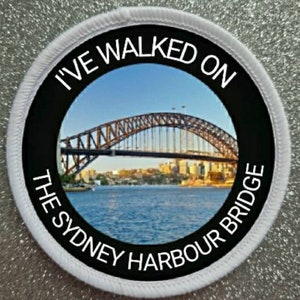 May include: A white round patch with black text that reads "I've walked on the Sydney Harbour Bridge". The patch has a photo of the Sydney Harbour Bridge in the center.