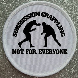 May include: White round patch with black text and silhouettes of two people grappling. The text reads "Submission Grappling Not For Everyone."