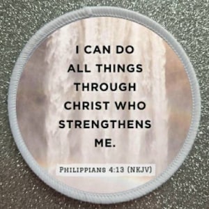 May include: A white round patch with a white border and a waterfall background. The text on the patch reads "I can do all things through Christ who strengthens me. Philippians 4:13 (NKJV)"