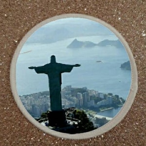 Puede incluir: Una silueta de la estatua del Cristo Redentor en Río de Janeiro, Brasil, con la ciudad y el océano en el fondo.
