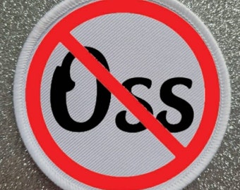 May include: A circular patch with a white background and a red circle with a diagonal line through it. The black letters "Oss" are inside the red circle. The patch has a white border.
