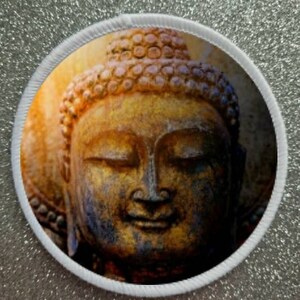 May include: Close-up of a golden Buddha statue with a serene expression. The statue has a detailed headpiece and a weathered, textured surface.