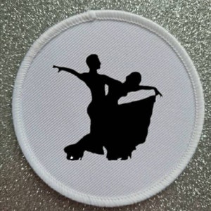 Peut inclure: Un écusson rond blanc avec une silhouette noire d'un couple dansant. L'homme mène la femme dans une pose de danse de salon.
