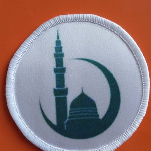 Puede incluir: Parche redondo blanco con un diseño de mezquita verde y luna creciente.