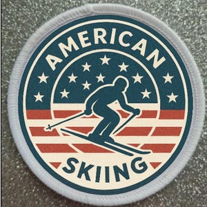 Peut inclure: Écusson rond à bordure blanche avec l'inscription "AMERICAN SKIING". Le motif représente un skieur bleu marine sur fond d'étoiles et de rayures du drapeau américain, en rouge, blanc et bleu. Un emblème sur le thème du ski.