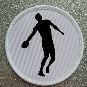 May include: A white round patch with a black silhouette of a person throwing a discus.