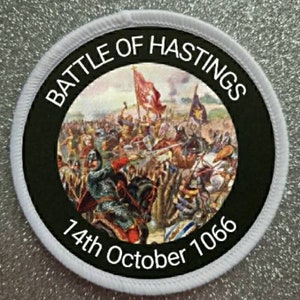 May include: A white circular patch with black text that reads "Battle of Hastings 14th October 1066". The center of the patch features a colorful illustration of the Battle of Hastings.