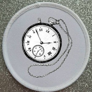 May include: A white round patch with a black and white illustration of a pocket watch with a chain. The watch face has Roman numerals and a smaller watch face inside.