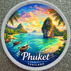 Può includere: Toppa rotonda con una vivace scena di spiaggia tropicale con la scritta "Phuket THAILANDIA". L'immagine raffigura un tramonto sull'oceano con barche, palme e montagne. La toppa ha un bordo bianco.