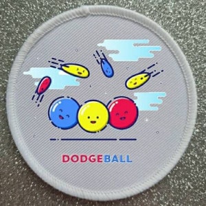 May include: A white circular patch with a grey background and a colourful illustration of a dodgeball game. Three dodgeballs with smiley faces are in the centre of the patch. Three dodgeballs are flying through the air. The text "DODGEBALL" is printed in red at the bottom of the patch.