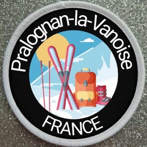 Könnte beinhalten: Ein weißer und schwarzer runder Patch mit dem Text "Pralognan-la-Vanoise FRANCE" in weiß. Der Patch zeigt eine Cartoon-Illustration einer Bergszene mit einem rot-weißen Ski, Skistöcken, einem roten Rucksack und Skischuhen.