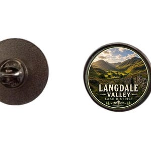 Könnte beinhalten: Runder Emaille-Pin mit einer Landschaft der Langdale Valley, Lake District. Der Pin hat einen schwarzen Rand und den Text "LANGDALE VALLEY - LAKE DISTRICT". Die Rückseite ist aus dunklem Metall mit einem Nadelverschluss.