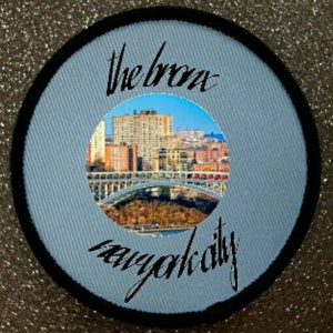 May include: A blue and black circular patch with the text "the bronx new york city" and a photo of a bridge and buildings in the center.