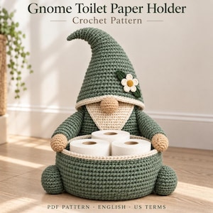 May include: A crochet gnome toilet paper holder pattern featuring a sage green pointed hat with a white flower, a beige beard, and a round nose. The gnome holds a round green basket containing three white toilet paper rolls. Text reads Gnome Toilet Paper Holder Crochet Pattern PDF PATTERN ENGLISH US TERMS.