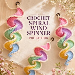 May include: Three crochet spiral wind spinners featuring a gradient of pink, purple, green, yellow, and blue yarn with a cream-colored border and a black hanging ring. The text CROCHET SPIRAL WIND SPINNER PDF PATTERN is centered in the image.