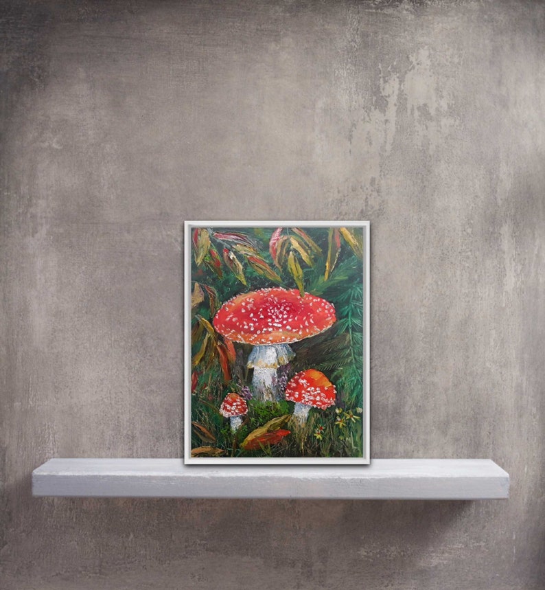 May include: A painting of three red and white mushrooms with white spots growing in a forest setting. The mushrooms are surrounded by green leaves and ferns.