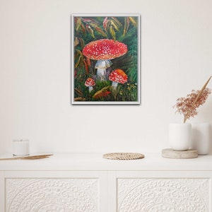 May include: A painting of three red and white mushrooms with white spots in a forest setting. The mushrooms are surrounded by green leaves and brown branches.