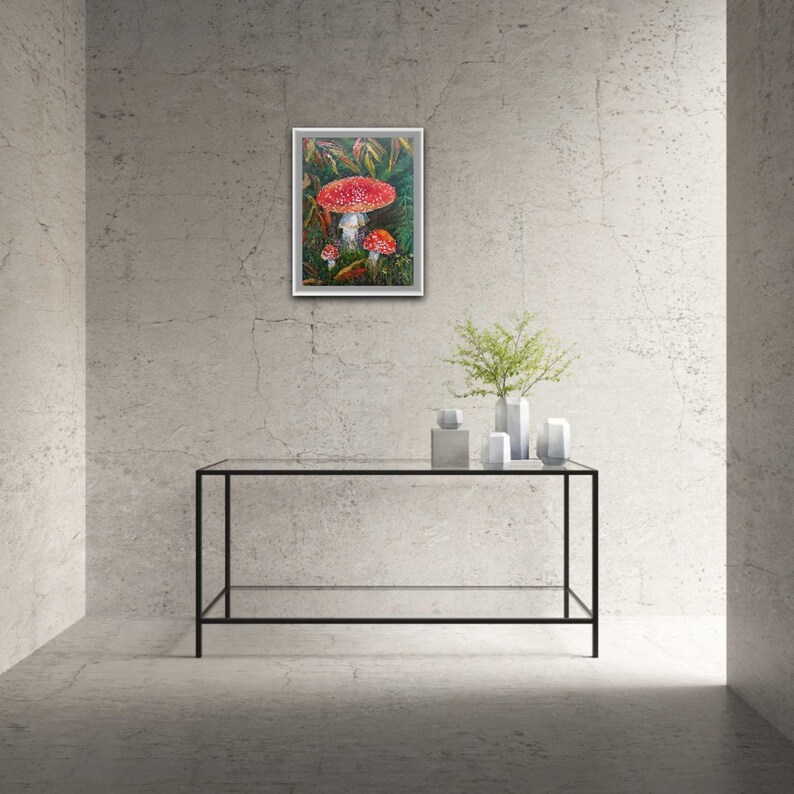 May include: A framed painting of red and white mushrooms in a green forest setting.
