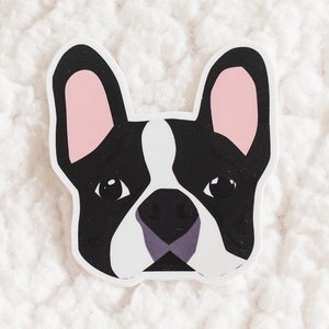 May include: A black and white cartoon illustration of a French bulldog's face with pink ears. The bulldog is looking directly at the viewer.