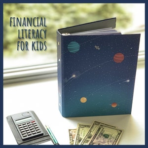 May include: A binder with a space-themed design, featuring planets and stars against a dark blue background. The text "FINANCIAL LITERACY FOR KIDS" is displayed on the left. A calculator, pen, and dollar bills are also visible.