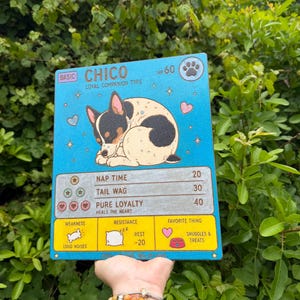 May include: A blue canvas featuring a cartoon dog illustration in a trading card style. The card reads "CHICO, LOYAL COMPANION TYPE" with HP 60. It includes stats like "Nap Time" and "Tail Wag," and "Snuggles & Treats" as a favorite thing.