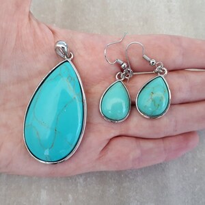 Puede incluir: Un conjunto de joyas turquesas con un colgante y pendientes a juego. Las piedras en forma de l&aacute;grima tienen un borde de metal plateado. El colgante es m&aacute;s grande que los pendientes. Las piedras turquesas tienen vetas marrones.