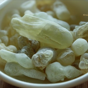 Pode incluir: Close-up de uma tigela branca cheia de peda&ccedil;os de resina amarelo p&aacute;lido e esbranqui&ccedil;ado. Os peda&ccedil;os de resina t&ecirc;m formas e texturas irregulares. A imagem tem foco suave e ilumina&ccedil;&atilde;o natural.