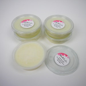 May include: A close-up of six small, clear plastic containers filled with a light yellow wax melt. Each container has a white label with the text "Millie Me Crafta 100% Soy Wax Freshly Made Bread Wax Melt".