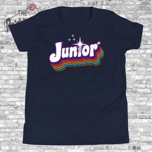 May include: A navy blue t-shirt with a retro-style rainbow graphic of the word "Junior" with a star and the letters "GS" in the upper right corner.
