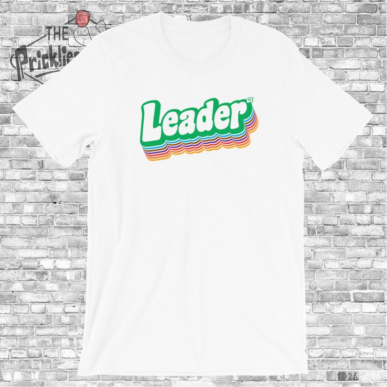 May include: White t-shirt with a green "Leader" graphic in a retro rainbow style.