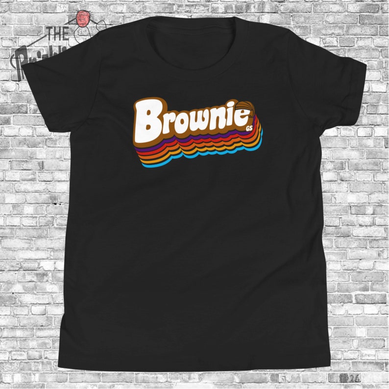 May include: Black t-shirt with a retro-style graphic of the word "Brownie" in brown, orange, yellow, blue, and red colors.