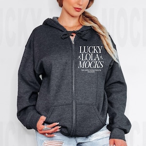 May include: A dark gray zip-up hoodie with a white graphic that says "LUCKY LOLA MOCKS" High quality mockups featuring real people.