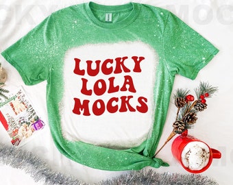 May include: Green bleached t-shirt with a white design that says "Lucky Lola Mocks" in red retro font.