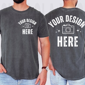 Puede incluir: Una camiseta gris oscuro con un gráfico de cámara blanco y el texto "YOUR DESIGN HERE" en la parte delantera y trasera.