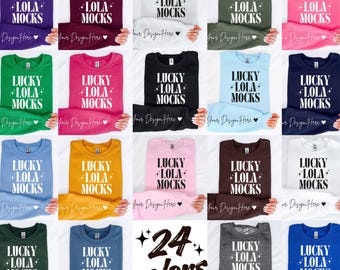 Può includere: Una collezione di ventiquattro felpe girocollo in vari colori a tinta unita, ognuna con la scritta bianca LUCKY LOLA MOCKS e dettagli a stella. L'assortimento include viola, bordeaux, bianco, oliva, rosa, verde, magenta, nero, azzurro, blu navy, blu, oro, rosa chiaro, marrone, verde scuro, grigio e blu reale.