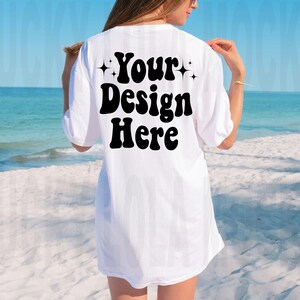 May include: White oversized t-shirt with the text "Your Design Here" in black retro font with stars on either side of the text.