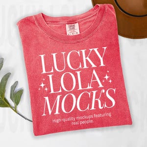 May include: Red t-shirt with white text that reads "LUCKY +LOLA+ MOCKS" and "High-quality mockups featuring real people."