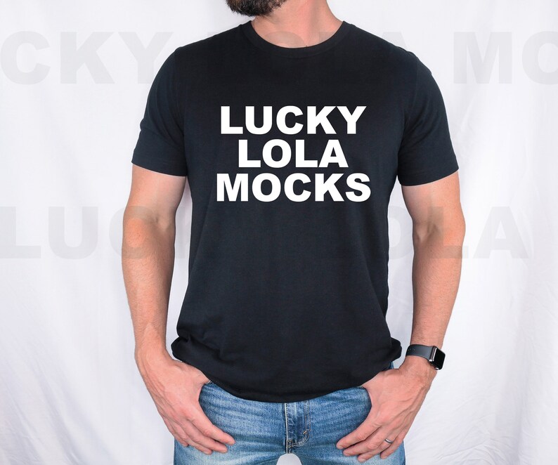 May include: A black t-shirt with white text that reads "LUCKY LOLA MOCKS". The person is wearing blue jeans.