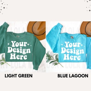 May include: Two crew neck sweatshirts, one light green and one blue, with the text "Your Design Here" in white retro font.