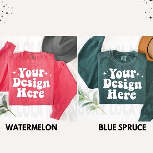 May include: Two blank sweatshirts, one in watermelon red and one in blue spruce green, with the text "Your Design Here" in white on the front.