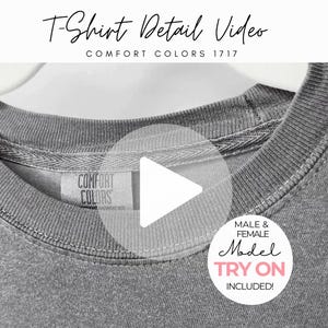 Könnte beinhalten: Nahaufnahme eines grauen Comfort Colors T-Shirts. Das Shirt hat einen Rundhalsausschnitt und ein Etikett mit der Aufschrift "COMFORT COLORS". Das Bild enthält auch den Text "T-Shirt Detail Video" und "MALE & FEMALE Model TRY ON INCLUDED!"