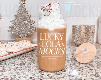 Puede incluir: Un tarro de vidrio con una tapa blanca y un líquido marrón en su interior. El tarro tiene el texto "Lucky Lola Mocks" y "High-quality mockups featuring real people" impreso en él. El tarro está sentado en una mesa con un fondo blanco.