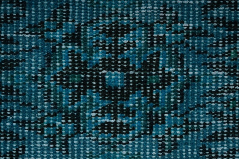 May include: A close-up of a blue and black patterned fabric with a textured surface.